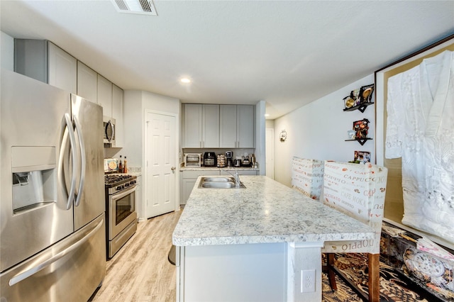 4338 Tulip Oak Dr, Houston, TX 77068 - kitchen with stainless steel appliances, light wood-style floors, light countertops, an island with sink, and recessed lighting