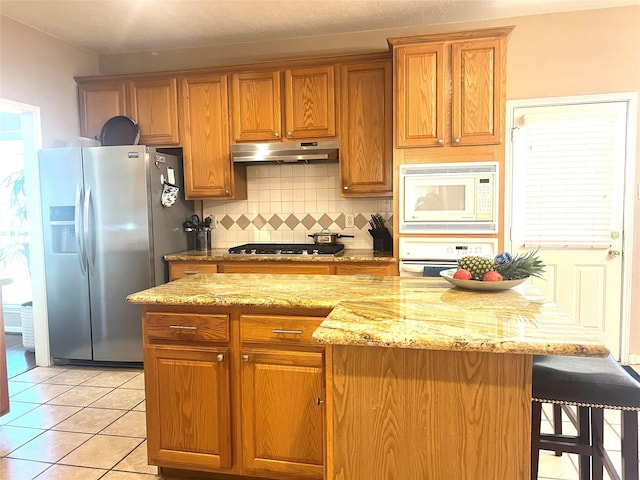 15415 Longhorn Cavern Dr, Sugar Land, TX 77498 - kitchen featuring appliances with stainless steel finishes, decorative backsplash, under cabinet range hood, and brown cabinets