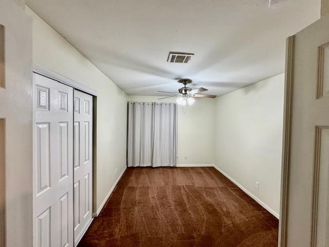 4418 Treasure Trl, Sugar Land, TX 77479 - unfurnished bedroom with dark carpet, a closet, and a ceiling fan
