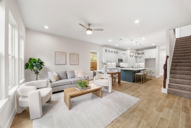 6216 Carver Rd, Houston, TX 77091 - living room featuring stairway, light wood-style flooring, a ceiling fan, and recessed lighting