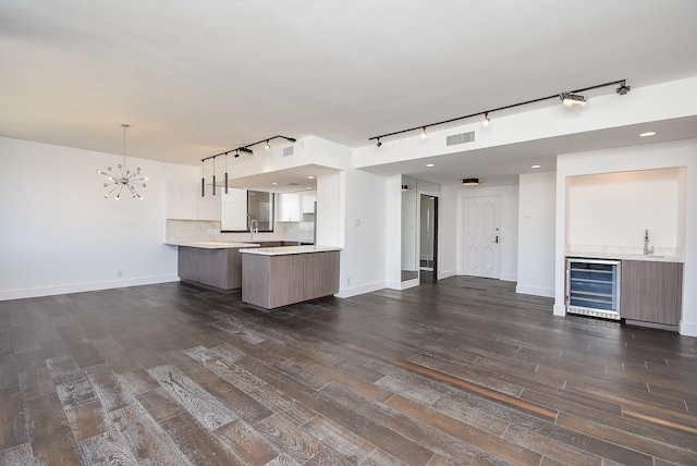49 Briar Hollow Ln Unit 1106, Houston, TX 77027 - kitchen featuring beverage cooler, open floor plan, rail lighting, light countertops, and a peninsula