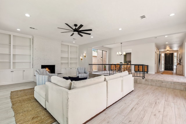 506 Fox Briar Ln, Sugar Land, TX 77478 - living area featuring a chandelier, light wood-style flooring, built in features, recessed lighting, and a brick fireplace
