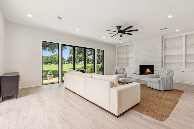 506 Fox Briar Ln, Sugar Land, TX 77478 - living area with a ceiling fan, a brick fireplace, light wood-style flooring, recessed lighting, and built in shelves