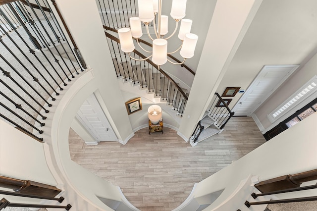 32647 Turning Springs Dr, Fulshear, TX 77423 - staircase featuring wood finished floors, a chandelier, and a high ceiling