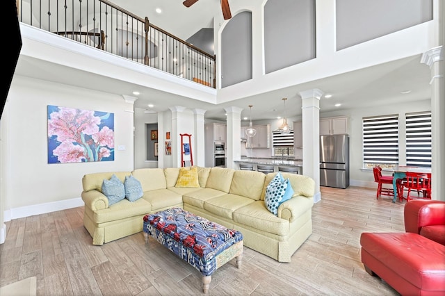 32647 Turning Springs Dr, Fulshear, TX 77423 - living area with ornate columns, light wood finished floors, a high ceiling, ceiling fan, and recessed lighting