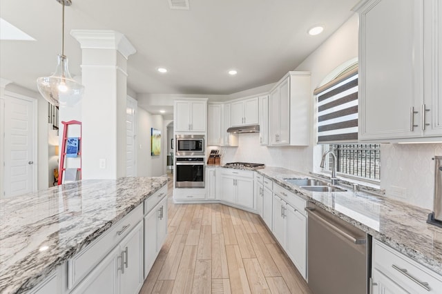 32647 Turning Springs Dr, Fulshear, TX 77423 - kitchen featuring appliances with stainless steel finishes, white cabinets, plenty of natural light, light wood finished floors, and recessed lighting