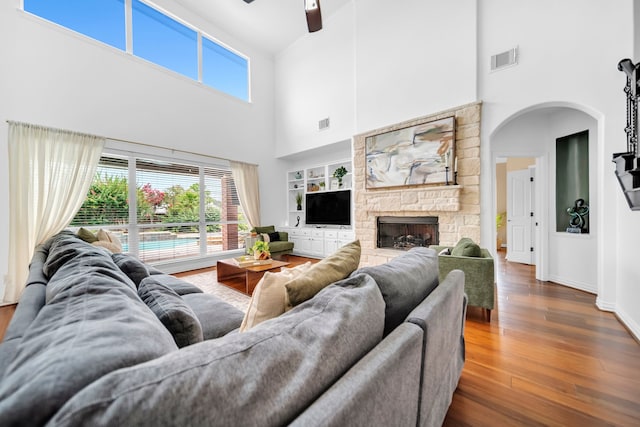12702 Eagle Ledge Ln, Tomball, TX 77377 - living room with a towering ceiling, plenty of natural light, a ceiling fan, arched walkways, and a stone fireplace