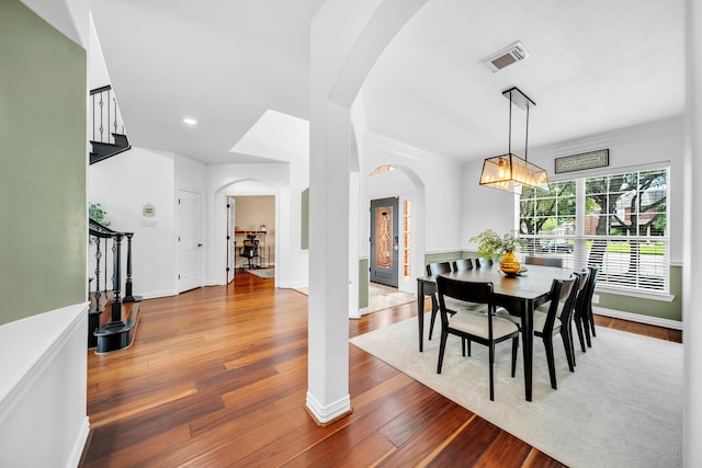 12702 Eagle Ledge Ln, Tomball, TX 77377 - dining area featuring arched walkways, wood finished floors, a chandelier, ornamental molding, and recessed lighting