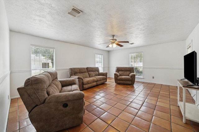 11937 Lakewood W Dr, Cypress, TX 77429 - tiled living room featuring plenty of natural light, a ceiling fan, and a textured ceiling
