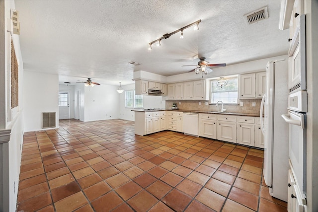 11937 Lakewood W Dr, Cypress, TX 77429 - kitchen featuring ceiling fan, white appliances, under cabinet range hood, open floor plan, and plenty of natural light