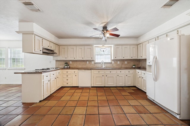 11937 Lakewood W Dr, Cypress, TX 77429 - kitchen featuring white appliances, a peninsula, tasteful backsplash, light tile patterned flooring, and a textured ceiling