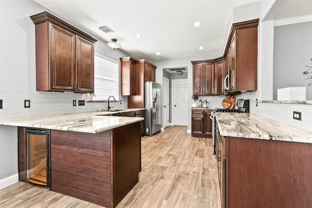 5403 Winlock Trace Ct, Katy, TX 77450 - kitchen with a peninsula, beverage cooler, appliances with stainless steel finishes, decorative backsplash, and light stone countertops