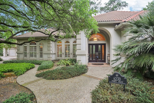 6230 Pebble Beach Dr, Houston, TX 77069 - view of exterior entry featuring french doors, a tile roof, and stucco siding