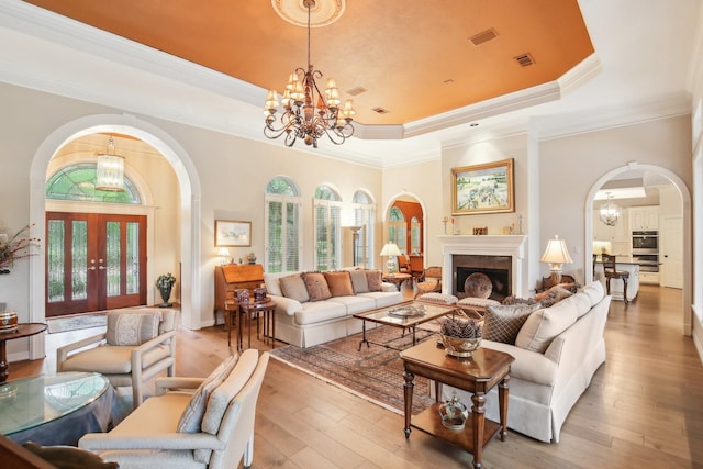 6230 Pebble Beach Dr, Houston, TX 77069 - living area featuring a chandelier, a raised ceiling, arched walkways, healthy amount of natural light, and crown molding
