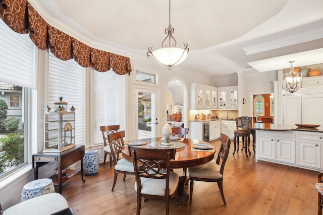 6230 Pebble Beach Dr, Houston, TX 77069 - dining space with beverage cooler, arched walkways, light wood-type flooring, ornamental molding, and a chandelier