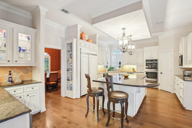 6230 Pebble Beach Dr, Houston, TX 77069 - kitchen with double oven, a breakfast bar, paneled built in refrigerator, a chandelier, and a center island