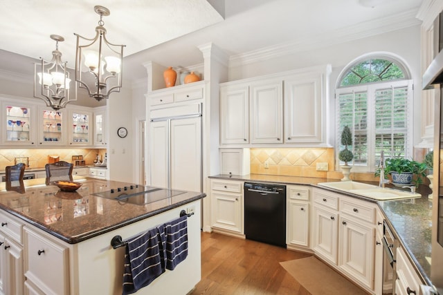 6230 Pebble Beach Dr, Houston, TX 77069 - kitchen with black appliances, decorative backsplash, a chandelier, wood finished floors, and crown molding