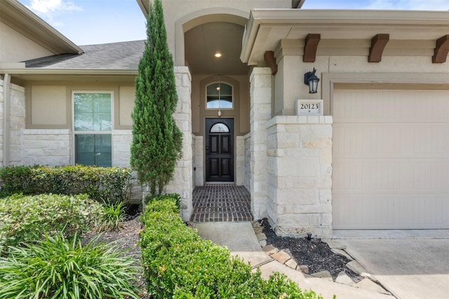 20123 Cascading Falls Blvd, Cypress, TX 77433 - doorway to property with stone siding, an attached garage, roof with shingles, and driveway