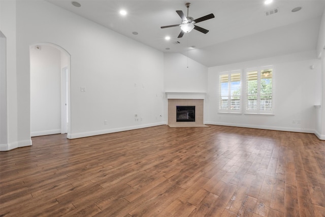20123 Cascading Falls Blvd, Cypress, TX 77433 - unfurnished living room featuring ceiling fan, hardwood / wood-style flooring, a tiled fireplace, arched walkways, and recessed lighting