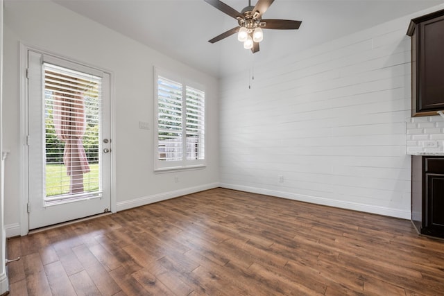 20123 Cascading Falls Blvd, Cypress, TX 77433 - unfurnished living room with dark wood-style flooring, ceiling fan, healthy amount of natural light, and wooden walls