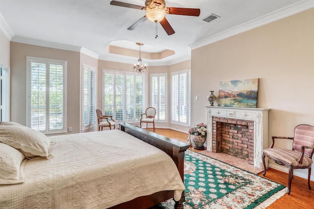 22806 Rachels Manor Dr, Katy, TX 77494 - bedroom with multiple windows, a chandelier, ornamental molding, a fireplace, and wood finished floors
