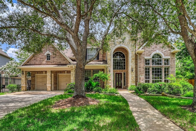 22806 Rachels Manor Dr, Katy, TX 77494 - view of front facade with driveway, an attached garage, stone siding, brick siding, and french doors