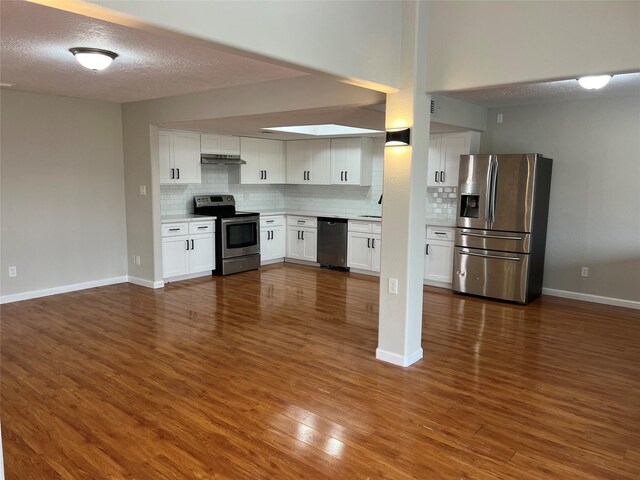 10719 Bellfair Dr, Houston, TX 77072 - kitchen with appliances with stainless steel finishes, backsplash, light countertops, white cabinets, and a textured ceiling