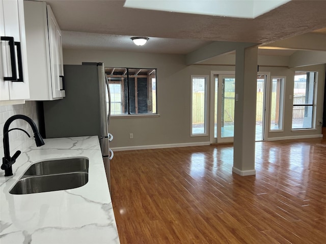 10719 Bellfair Dr, Houston, TX 77072 - kitchen featuring open floor plan, white cabinetry, light stone counters, tasteful backsplash, and wood finished floors