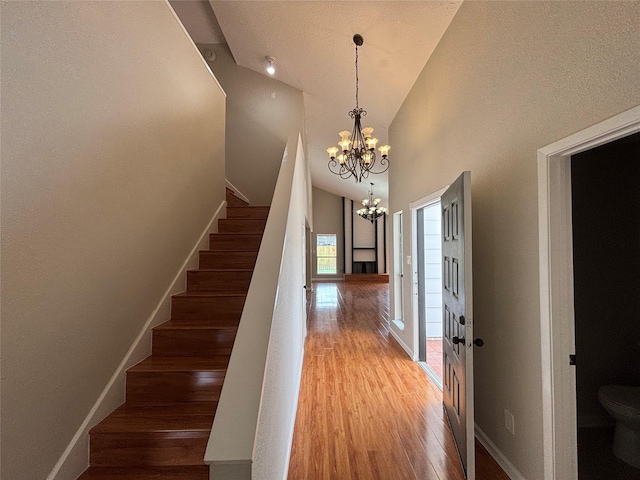 10719 Bellfair Dr, Houston, TX 77072 - stairs featuring a chandelier, wood finished floors, and high vaulted ceiling
