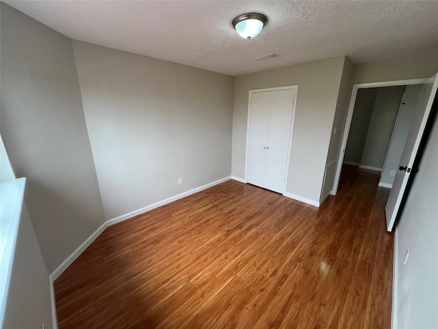 10719 Bellfair Dr, Houston, TX 77072 - unfurnished bedroom with wood finished floors, a textured ceiling, and a closet