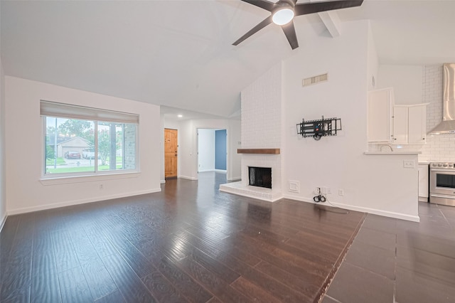 3407 Hillstone Dr, Sugar Land, TX 77479 - unfurnished living room with a ceiling fan, a brick fireplace, high vaulted ceiling, dark wood-style flooring, and beamed ceiling