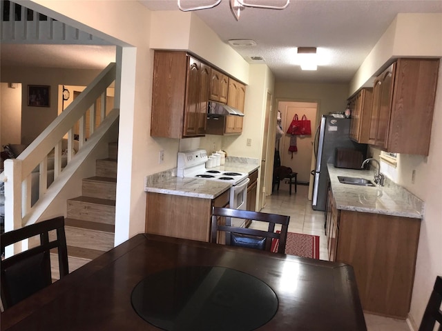 6203 Gladewell Dr, Houston, TX 77072 - kitchen featuring white electric stove, under cabinet range hood, freestanding refrigerator, and light stone countertops