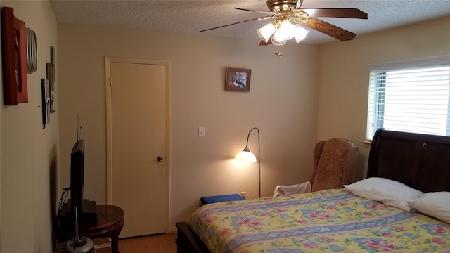 6203 Gladewell Dr, Houston, TX 77072 - bedroom featuring light wood-style flooring, a textured ceiling, and a ceiling fan