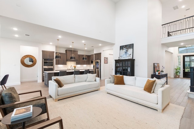 11111 Heartleaf Aster Way, Cypress, TX 77433 - living room featuring light wood-style floors, a towering ceiling, and recessed lighting