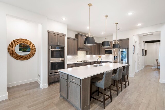 11111 Heartleaf Aster Way, Cypress, TX 77433 - kitchen featuring appliances with stainless steel finishes, light wood finished floors, tasteful backsplash, light countertops, and recessed lighting