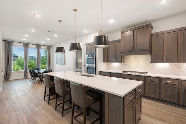 11111 Heartleaf Aster Way, Cypress, TX 77433 - kitchen featuring appliances with stainless steel finishes, light countertops, a center island with sink, backsplash, and recessed lighting