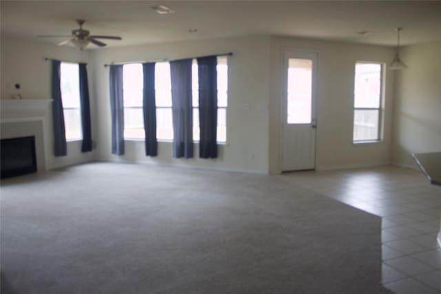 26350 Riley Glen Dr, Richmond, TX 77406 - unfurnished living room with carpet, a fireplace, and a ceiling fan