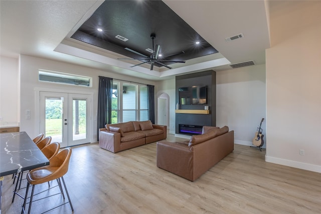 1000 Denson Allen Rd, Coldspring, TX 77331 - living room with a tray ceiling, light wood-type flooring, ceiling fan, and french doors