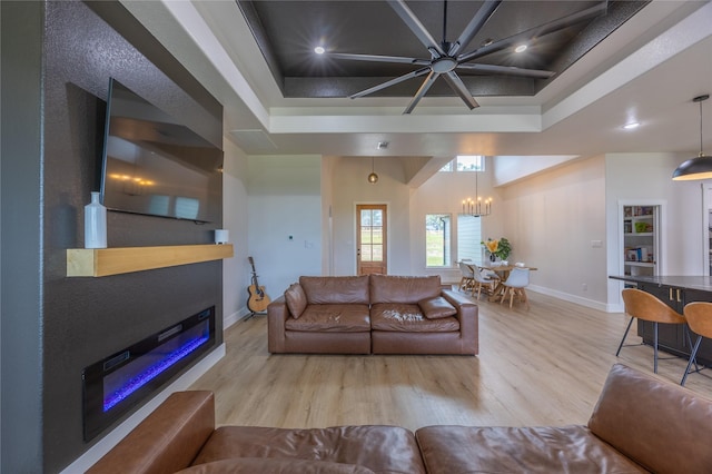 1000 Denson Allen Rd, Coldspring, TX 77331 - living room featuring wood finished floors, a glass covered fireplace, a chandelier, a raised ceiling, and recessed lighting
