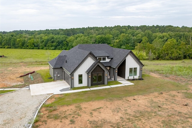 1000 Denson Allen Rd, Coldspring, TX 77331 - modern inspired farmhouse featuring driveway, a wooded view, board and batten siding, and roof with shingles