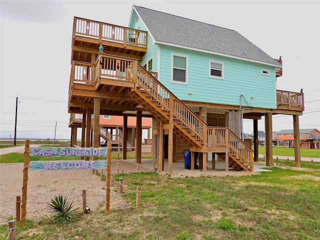 110 Pelican Pl, Surfside Beach, TX 77541 - rear view of house featuring stairs, roof with shingles, a carport, and a lawn