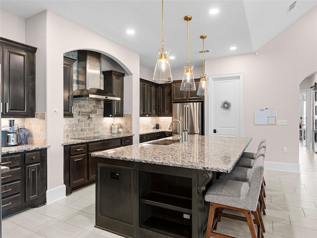 18114 Rainwater Creek Ln, Cypress, TX 77433 - kitchen featuring wall chimney range hood, stainless steel fridge, tasteful backsplash, open shelves, and arched walkways