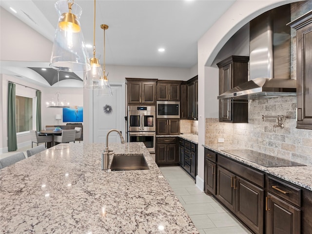 18114 Rainwater Creek Ln, Cypress, TX 77433 - kitchen featuring wall chimney range hood, appliances with stainless steel finishes, dark brown cabinets, decorative backsplash, and light stone countertops