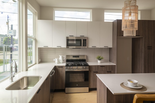 5404 Mulvey St, Houston, TX 77020 - kitchen featuring stainless steel appliances, modern cabinets, light countertops, and backsplash