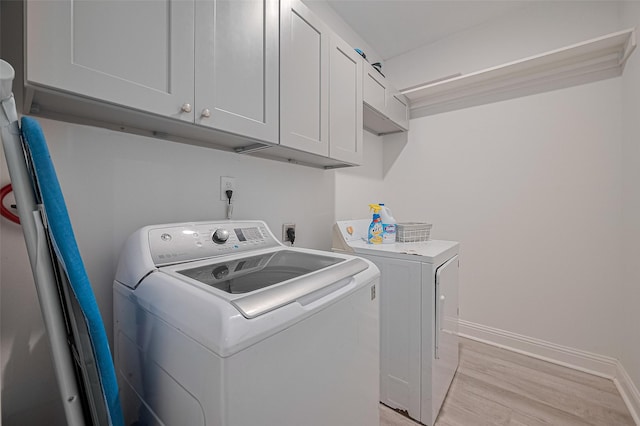 6507 Pinewood Trace Ln, Houston, TX 77041 - laundry room featuring washer and dryer, cabinet space, and light wood finished floors