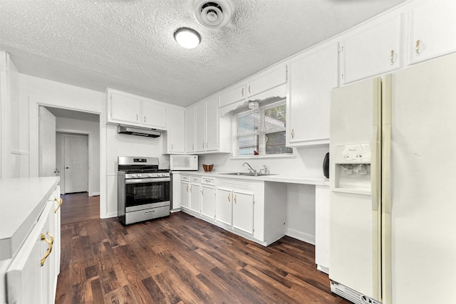 2801 John St, La Marque, TX 77568 - kitchen with white appliances, under cabinet range hood, dark wood finished floors, white cabinets, and a textured ceiling