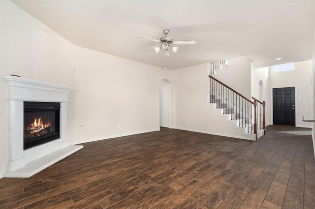 24727 Lake Basin Ct, Katy, TX 77493 - unfurnished living room with arched walkways, wood finished floors, and stairs