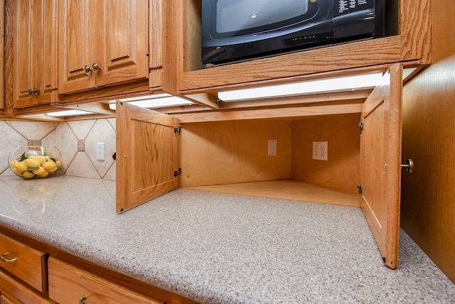 3003 Bernadette Ln, Houston, TX 77043 - kitchen view of backsplash, black microwave, and brown cabinetry