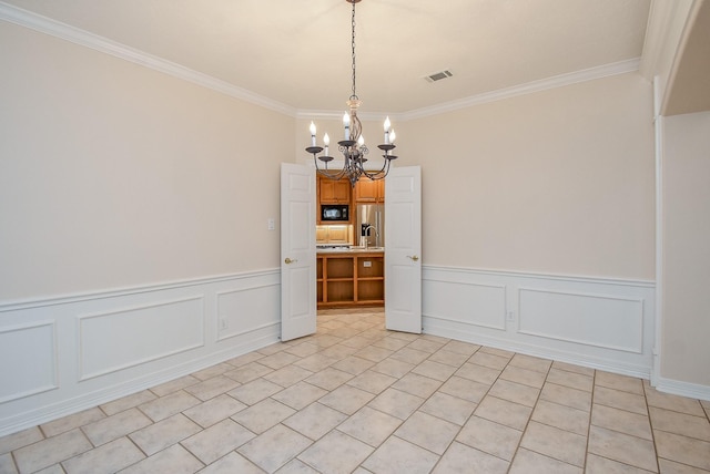 3003 Bernadette Ln, Houston, TX 77043 - empty room featuring a chandelier, crown molding, a wainscoted wall, light tile patterned floors, and a decorative wall