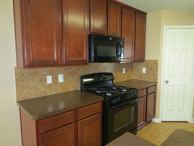 22303 Bridgestone Ridge Dr, Spring, TX 77388 - kitchen featuring black appliances, decorative backsplash, light tile patterned floors, and dark countertops